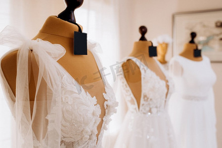 丝质裙子摄影照片_美丽的白色婚纱挂在人体模特身上