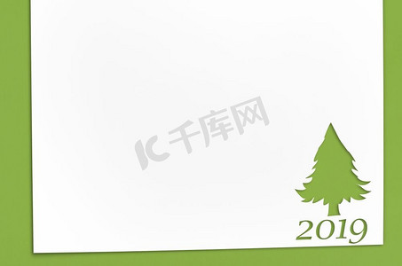 削减在冷杉树形状的纸为圣诞卡或新年背景在绿色桌子。桌上的冷杉形剪纸