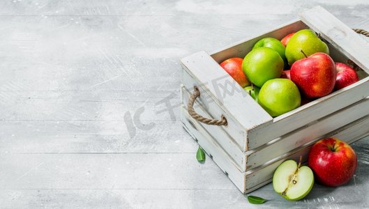 多汁的新鲜绿色和红色苹果在一个木箱在白色乡村背景多汁的新鲜绿色和红色苹果在一个木箱。