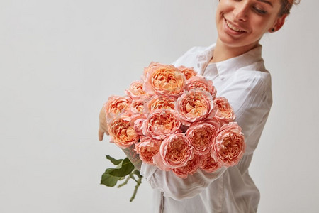快乐的微笑的女孩拿着一大束粉红色的玫瑰。情人节，母亲节。’’一束花的女孩