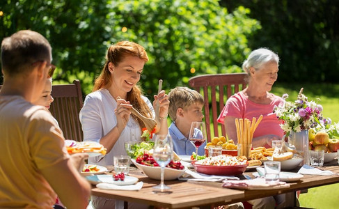 消闲、度假和人的概念—欢乐的家庭聚餐或夏季花园聚会。快乐的家庭有晚餐或夏季花园聚会
