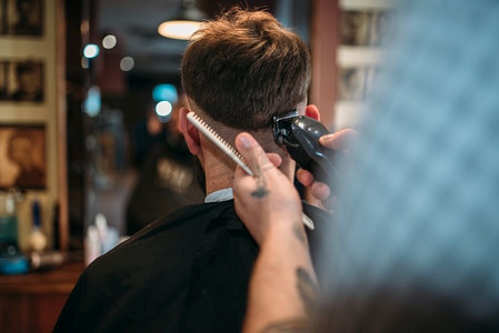 理发师的手用剪刀做客户男人的发型复古相机人物特写