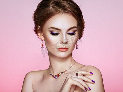 肖像美丽的女人与珠宝。模特女孩与紫色美甲指甲。优雅的发型紫色化妆箭美容及配饰