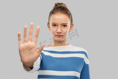 抗议和人们的观念-身穿格子衬衫的少女在灰色背景下做出停止手势.