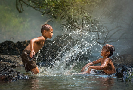 在河的亚洲儿童/男孩朋友愉快的滑稽玩耍的水在水的溪流在生活的农村的孩子农民农村人