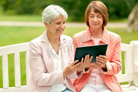技术，老年和人的概念—老年妇女与平板电脑电脑在夏季公园。高级妇女与平板电脑在夏季公园