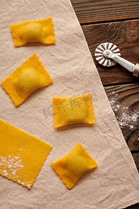 美味的生的自制馄饨意大利面与菠菜和意大利乳清干酪在木的乡村背景。制作意大利馄饨的过程。 