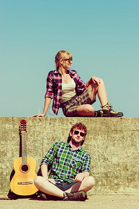 年轻人玩吉他给他的女朋友户外海滨约会夫妇