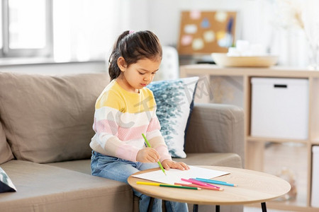 童年，创造力和艺术概念—小女孩在家里用彩色铅笔画画。小女孩画与彩色铅笔在家里