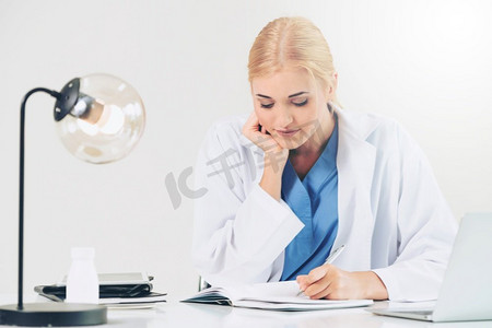 健康报告摄影照片_女医生在医院或保健研究所工作的医疗报告在办公桌。医生在医院做医疗报告。