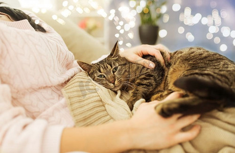 宠物、卫生与人的概念--女主人在家中与猫猫在床上的特写。主人与猫猫在家中床上的特写