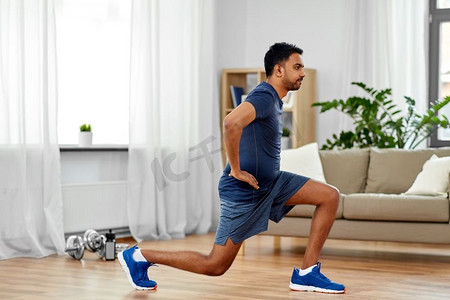 健身、运动和健康的生活方式理念--印度男人在家锻炼和做冲刺。一名印度男子在家中锻炼和跳跃