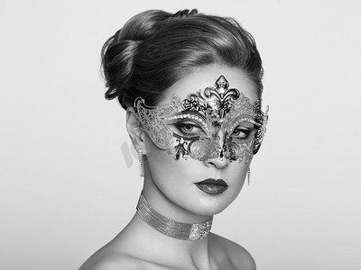 化妆活动摄影照片_美丽的女人穿着威尼斯化妆舞会狂欢节面具在党，在白色背景。圣诞节和新年庆祝活动。黑白照片