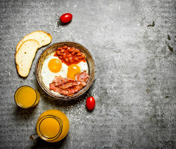 早上吃早餐。咸肉，鸡蛋和橙汁。在石桌上。咸肉，鸡蛋和橙汁。
