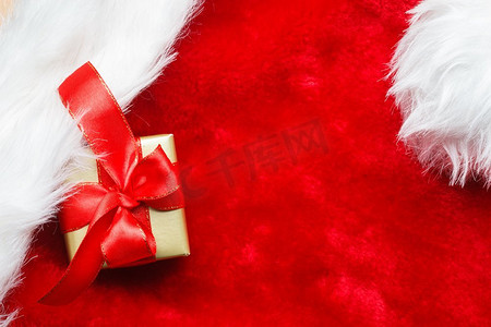 周年福礼摄影照片_节日，礼物，圣诞节的概念。小金盒与礼品系在红色背景装饰弓