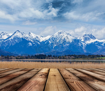 木板地板，背景是巴伐利亚阿尔卑斯山乡村湖泊景观。德国巴伐利亚州。带有巴伐利亚阿尔卑斯山景观的木板地板