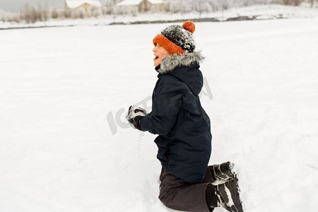 童年，休闲和季节概念—快乐的小男孩玩雪在冬天。快乐的小男孩玩雪在冬天