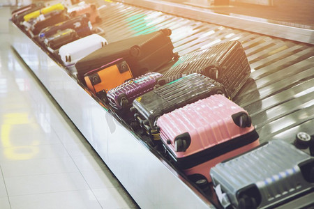 行李箱店铺摄影照片_行李箱或行李在国际机场行李领取处循环传送带。	