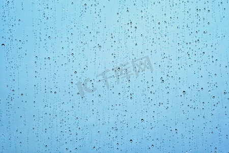 股价下降摄影照片_雨水滴在窗玻璃纹理背景的水滴。雨点落在窗户上