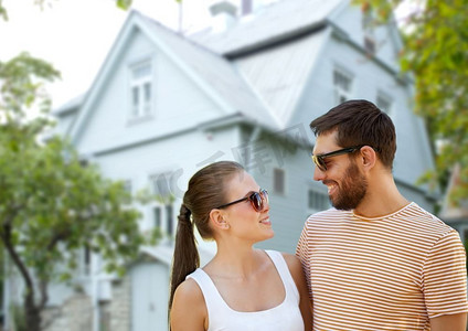 人和关系概念—愉快的夫妇在太阳镜在夏天在居住的房子背景快乐的夫妇在太阳镜在夏天超过房子