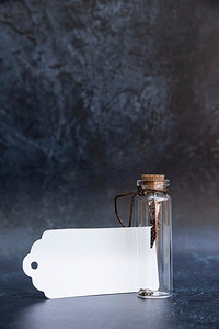 老书桌摄影照片_浪漫的老葡萄酒玻璃愿望瓶与好运气魅力在瓶子里面有软木盖和古董效果背景和空白标签为文本