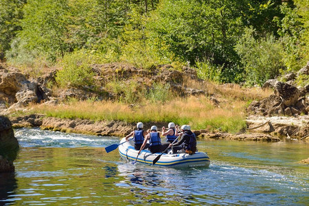 人划船摄影照片_专业的漂流队与指导白水漂流和划船在河上