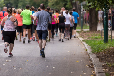 一群健康的人在城市公园慢跑，跑步者团队在晨练