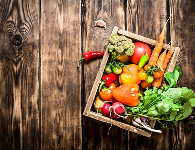 健康食品。有机蔬菜装在一个旧盒子里。在木质背景上..健康食品。有机蔬菜装在一个旧盒子里。