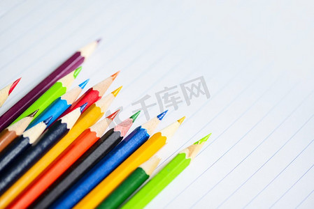 文具用品海报摄影照片_彩色铅笔设置在白纸笔记本回到学校和教育概念/蜡笔五颜六色
