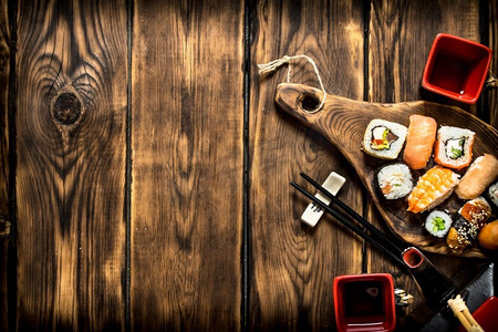 金枪鱼卷寿司摄影照片_寿司和卷配凉茶。在一张木桌上..寿司和卷配凉茶。