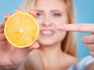 健康的饮食，清爽的食物富含维生素。女人拿着甜蜜美味的柑橘水果，柠檬在橙子。妇女拿着水果柠檬或橙子