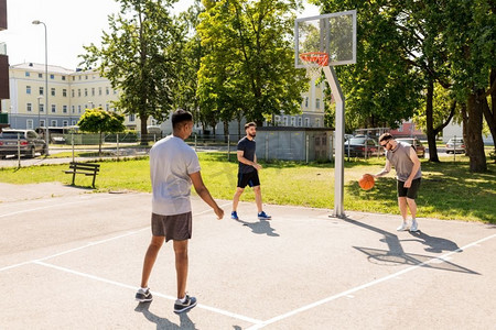 街头篮球摄影照片_运动、休闲游戏和男性友谊的概念--一群男人或朋友在街头打篮球。一群在街头打篮球的男性朋友