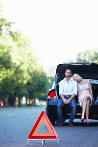 紧急道路标志的背景的一对夫妇在车里爱