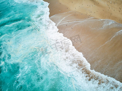 北海滩在纳扎尔葡萄牙与泡沫波浪和飞行海鸥