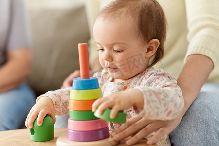 童年和发展的概念—可爱的女婴在家里玩玩具金字塔。可爱的女婴玩玩具金字塔在家里