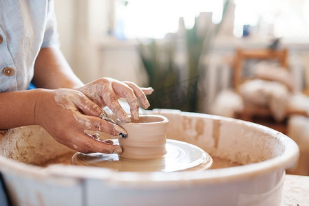女陶工在陶轮上做锅。女人在做碗的模子。手工陶艺，粘土餐具
