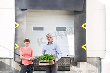 主人的肖像与板条箱站在女植物学家反对植物苗圃