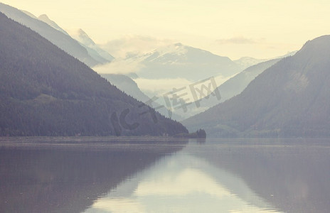 宁静的景色由山湖在加拿大与岩石在平静的水中的反射。