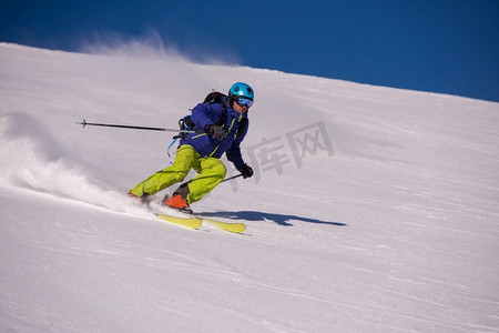 年轻的自由式滑雪运动员，在冬季晴朗的日子里，在美丽的阿尔卑斯山风景中享受着下坡的乐趣