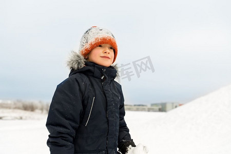 户外雪摄影照片_童年，休闲和季节概念—快乐的小男孩在冬季衣服户外。快乐的小男孩在冬季衣服户外