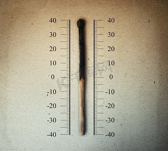 在温度计等刻度上指示温度的燃烧的火柴。全球变暖和升温的概念