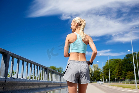 健身、运动和健康的生活方式理念--运动的年轻女性在户外跑步。健美的年轻女子在户外奔跑
