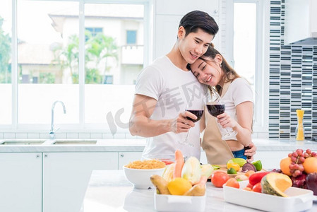 情人节主题摄影照片_亚洲情侣或情侣在家中的厨房里喝酒。爱情幸福观甜蜜蜜月情人节主题