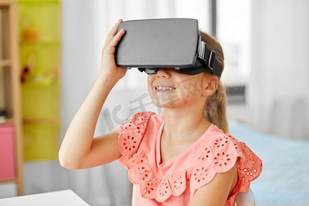 技术，增强现实和娱乐概念—女孩与虚拟耳机或虚拟现实眼镜在家里玩。女孩在vr眼镜在家里