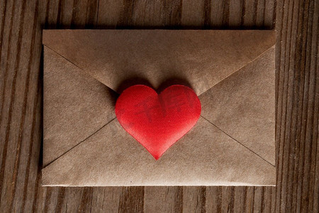 情人节情书，木质背景红心工艺纸信封。情人节情书