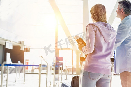 行李车摄影照片_肖像男子推行李车办理登机手续与她的女儿在机场