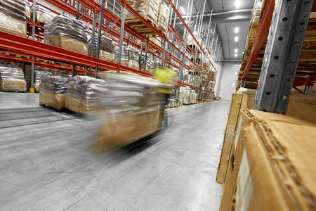 物流业务，装运和装载概念—工人搬运装载机与货物在仓库。工人在仓库搬运货物