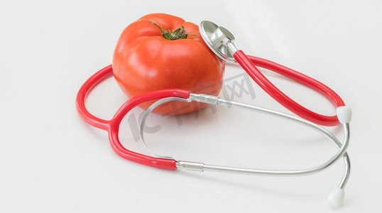 健康的食物概念—番茄和医生听诊器在白色背景显示维生素和营养素在番茄的好处。