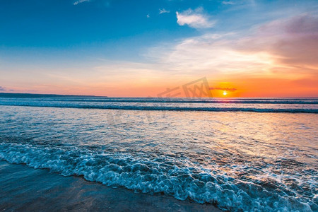 令人惊叹的日落从巴厘岛双六海滩冲浪波浪和五颜六色的云。从巴厘岛海滩惊人的日落