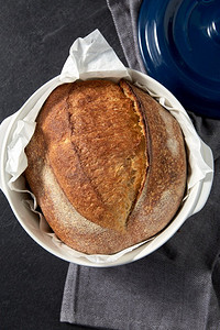 食物和烹饪概念-自制工艺面包，放在餐桌上的陶瓷烤盘中。陶瓷烤盘自制工艺面包